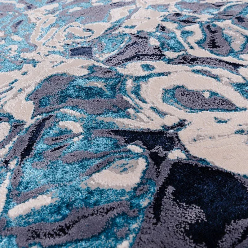 Close view of abstract blue and cream area rug with textured pattern