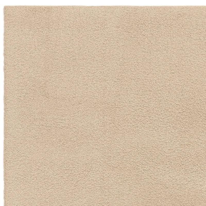 Beige shaggy area rug with soft textured pile, shown from a top corner angle