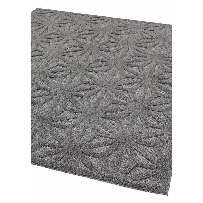 Grey patterned area rug with raised geometric floral design, corner angled view
