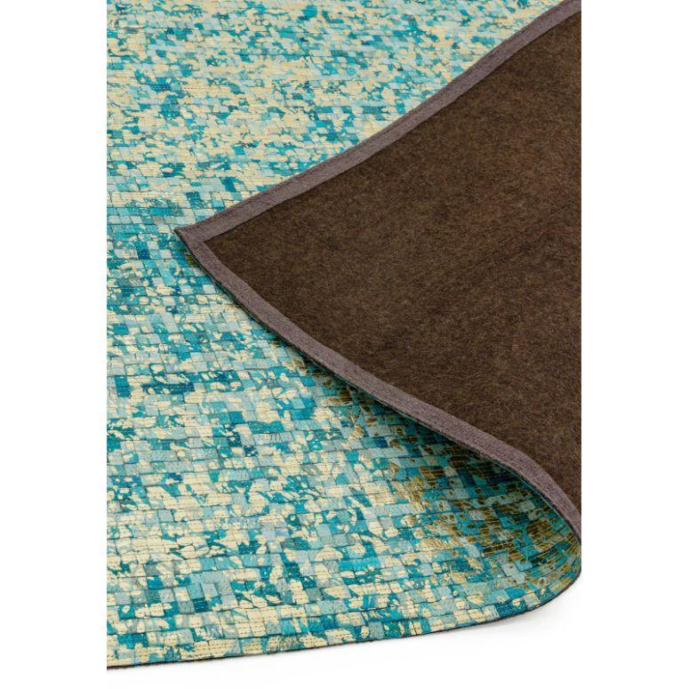 Blue and beige patterned area rug corner flipped to show non-slip brown backing