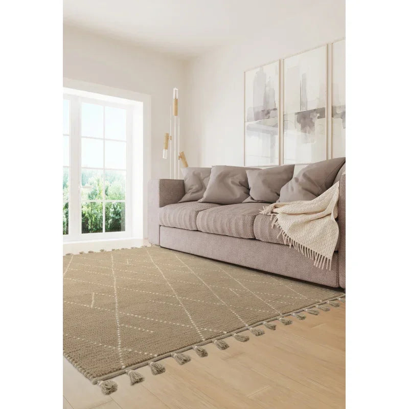 Beige woven rug with tassels in living room, styled with modern sofa and abstract wall art