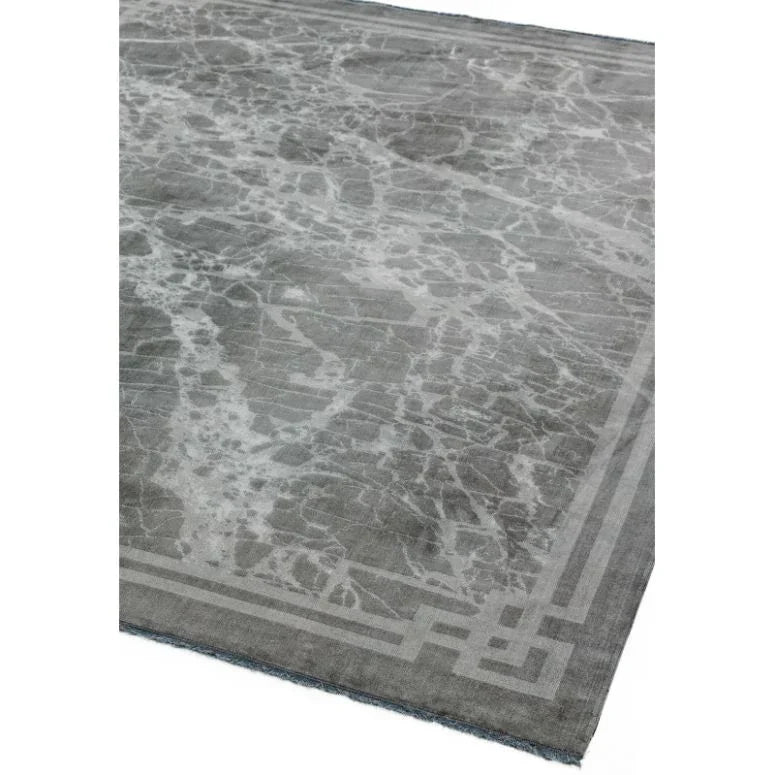 Grey marble effect rug with geometric border, corner angle view showing modern pattern