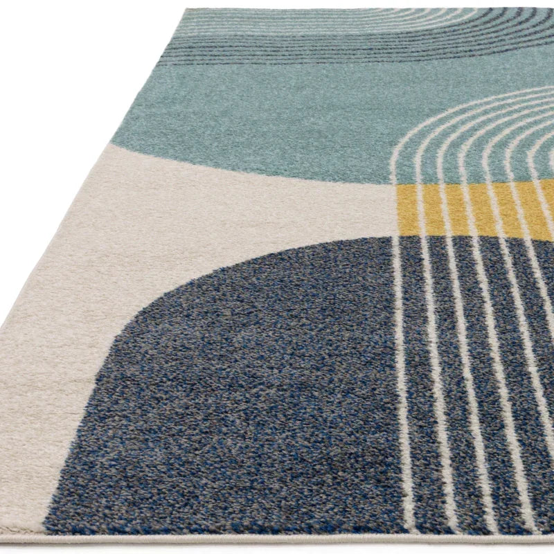 Modern rug with blue, teal, yellow and cream geometric pattern, close-up angle