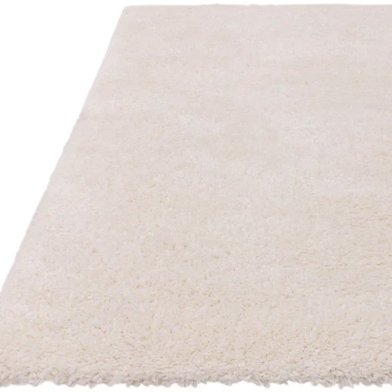Rectangular cream shaggy rug with soft, high-pile texture, close-up corner view