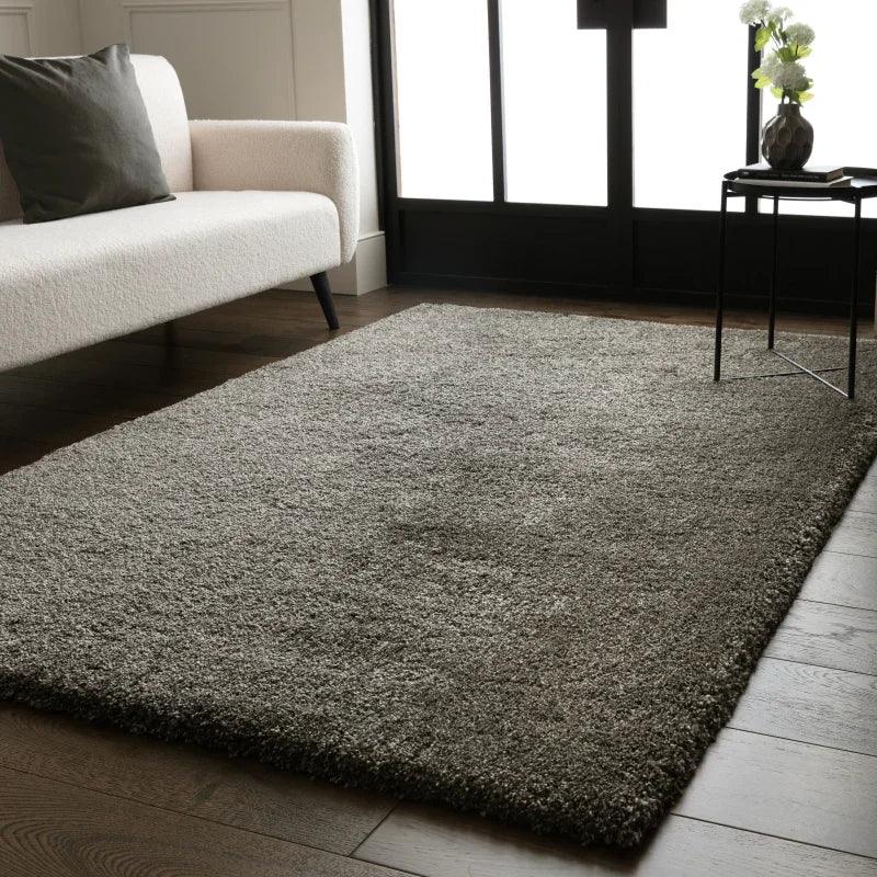 Grey shaggy rug on wooden floor beside cream sofa in modern living room