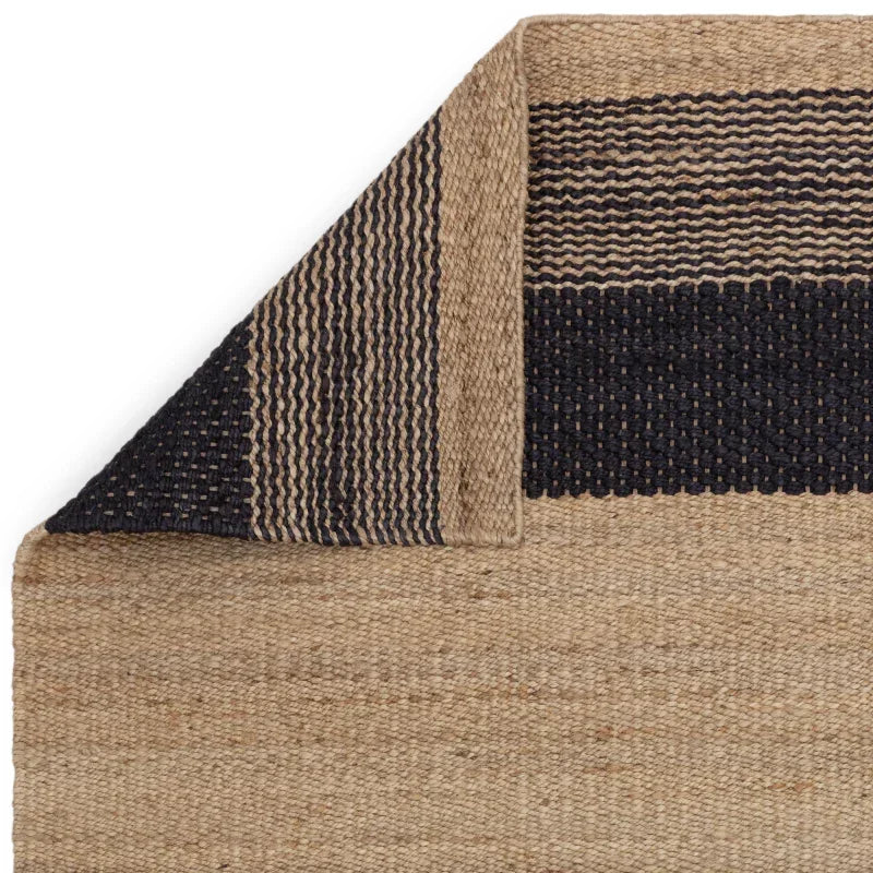 Jute rug with natural and black woven stripes, closeup of corner detail and texture