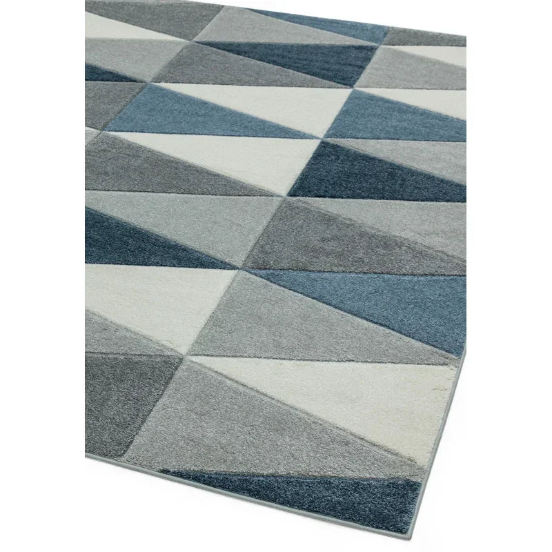 Blue and grey geometric rug with triangle pattern, shown from angled corner view