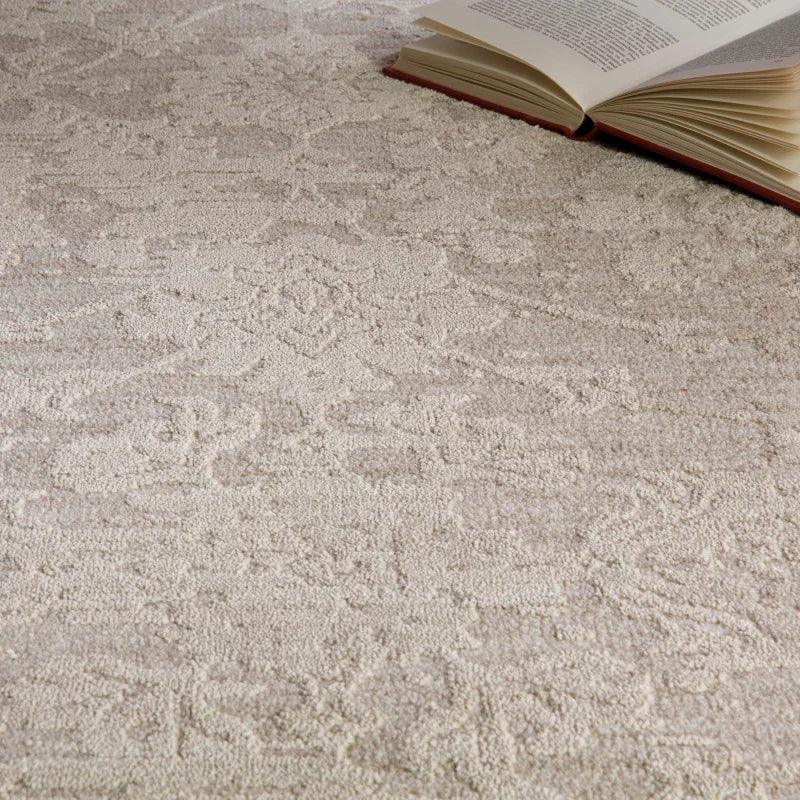 Cream textured rug with subtle pattern and open book on surface