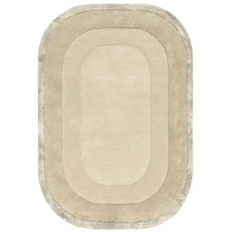 Oval beige area rug with plush border and soft textured surface