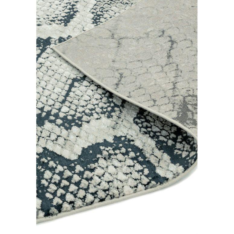 Modern patterned area rug with textured blue and cream design, close-up corner view