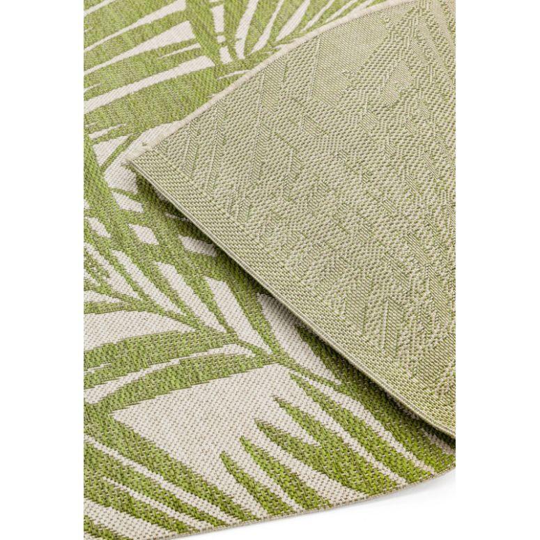 Green and beige outdoor rug with palm leaf pattern, close-up of corner detail