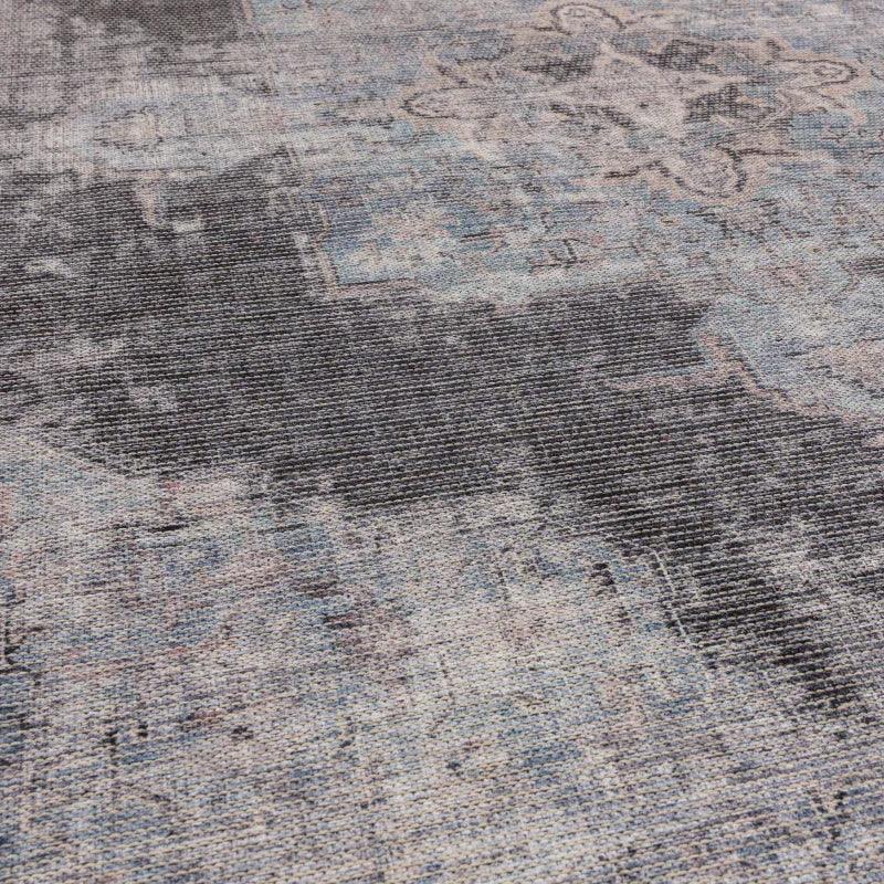 Blue and grey distressed area rug with subtle geometric pattern, close-up texture view