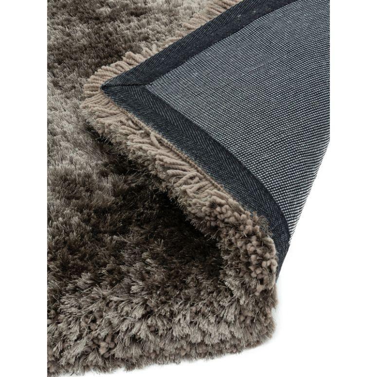Close-up of grey shaggy carpet with soft pile and textured backing