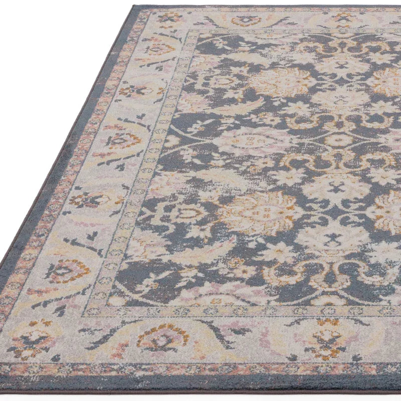 Blue and cream area rug with floral pattern and detailed border, corner view