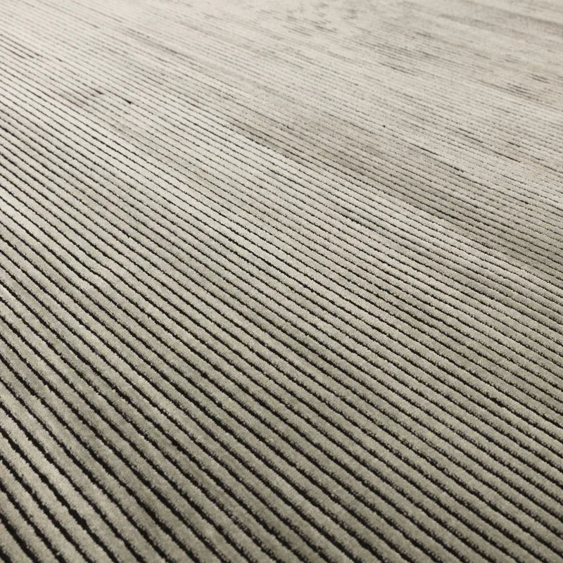 Beige corduroy sofa fabric texture with fine vertical ribbed pattern, close-up view