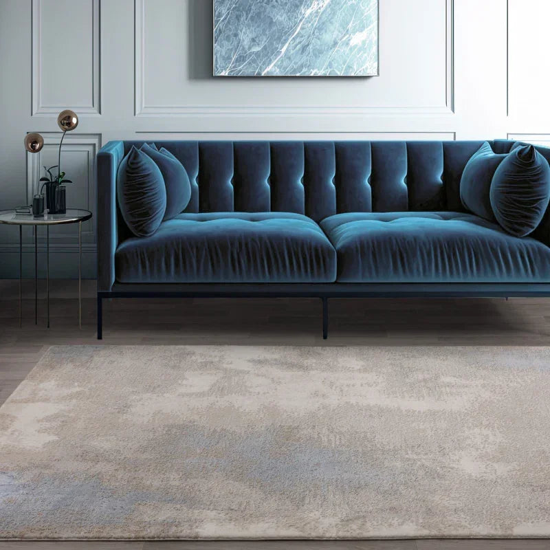 Blue velvet sofa with tufted backrest and matching cushions in modern living room