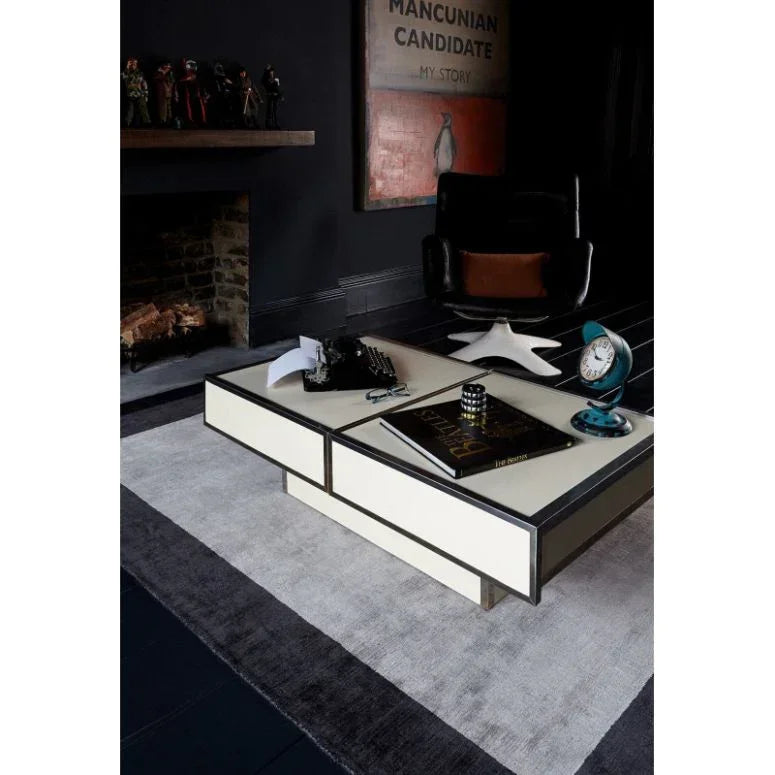Modern cream coffee table on a grey rug with black trim in a contemporary living room