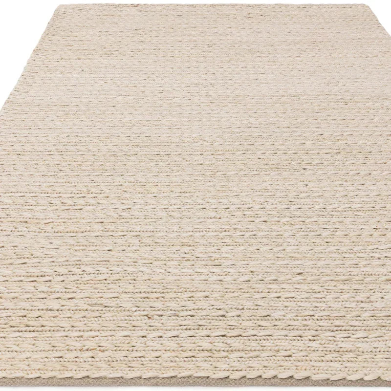 Beige woven area rug with textured braided pattern and rectangular shape