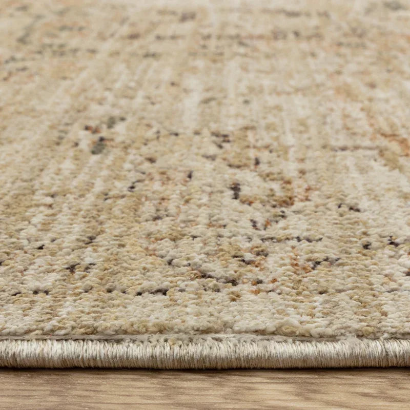 Beige patterned area rug with low pile texture on wooden floor, side profile closeup