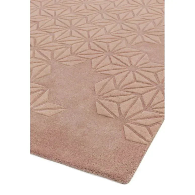 Blush pink geometric embossed rug corner with raised diamond pattern
