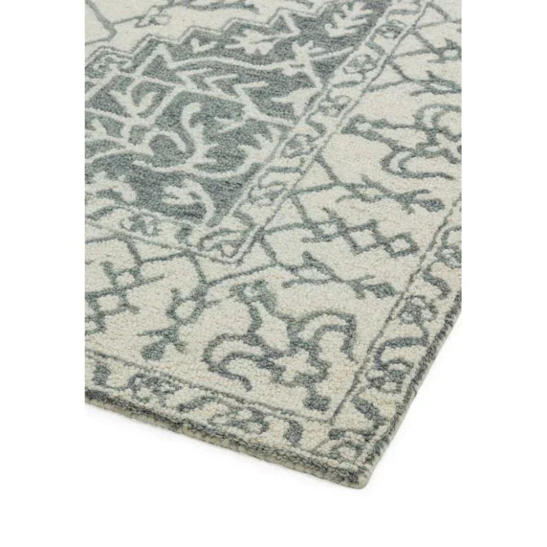 Close up of patterned wool rug with blue and cream geometric design and border