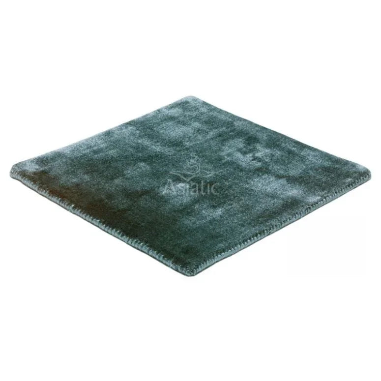 Square dark green velvet rug with stitched edge, shown from angled top view