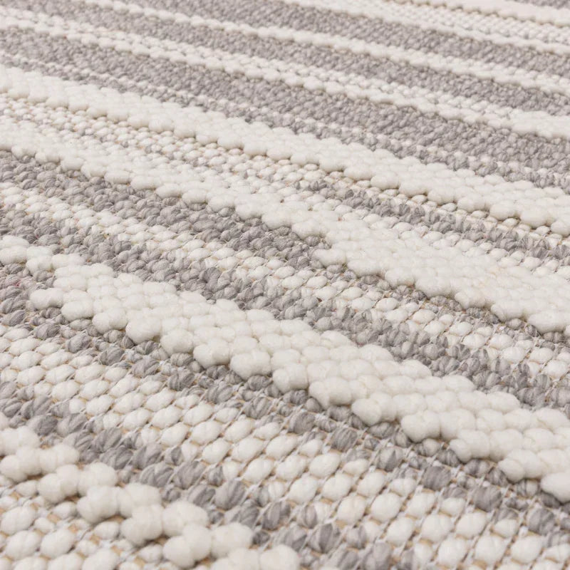 Close-up of grey and cream textured wool rug with striped woven pattern