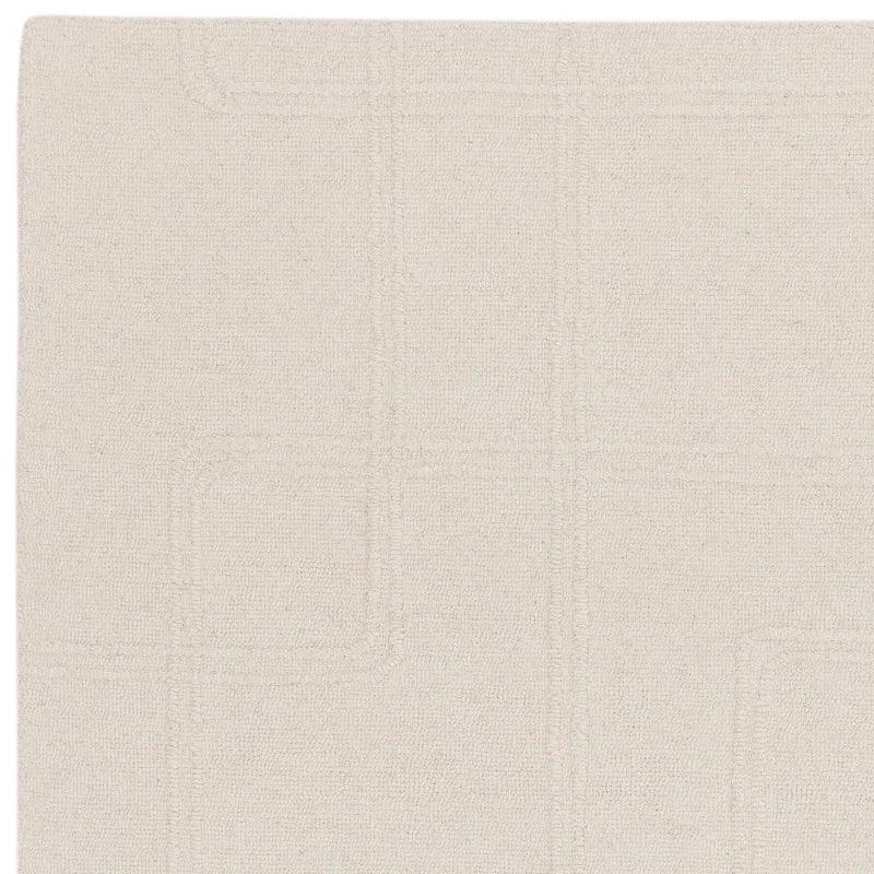Beige textured rug with subtle line pattern detail, closeup of fabric surface