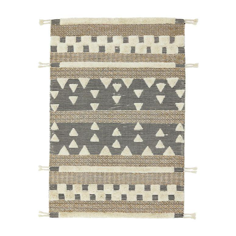 Geometric patterned rug with black, beige and cream stripes, fringe edges, and triangle details