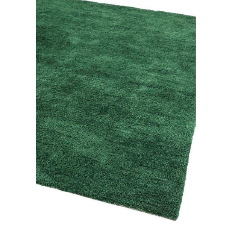 rectangular green wool area rug with soft textured surface, corner angle view