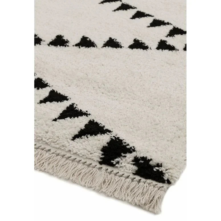 Cream and black geometric rug with fringe edge and textured pile