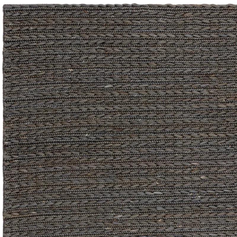 Grey braided rug with textured woven jute pattern, close-up of rug surface