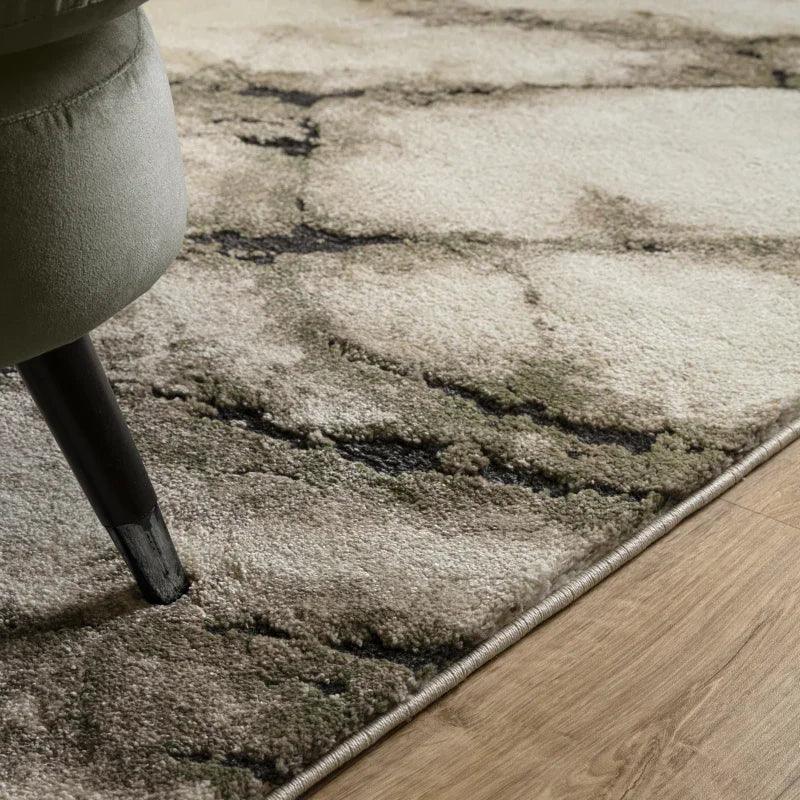 Modern area rug with marble pattern beside sofa leg on wood flooring