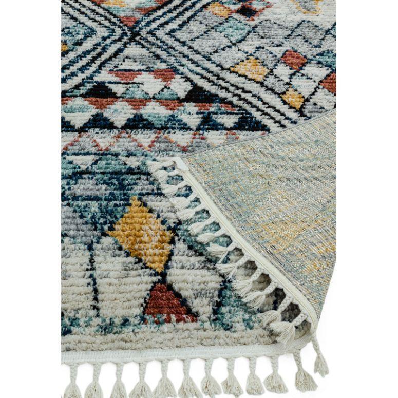 Geometric pattern rug with tassels in blue, yellow, red and cream, corner folded over