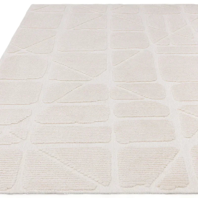 Ivory area rug with geometric textured pattern and soft pile, angled view