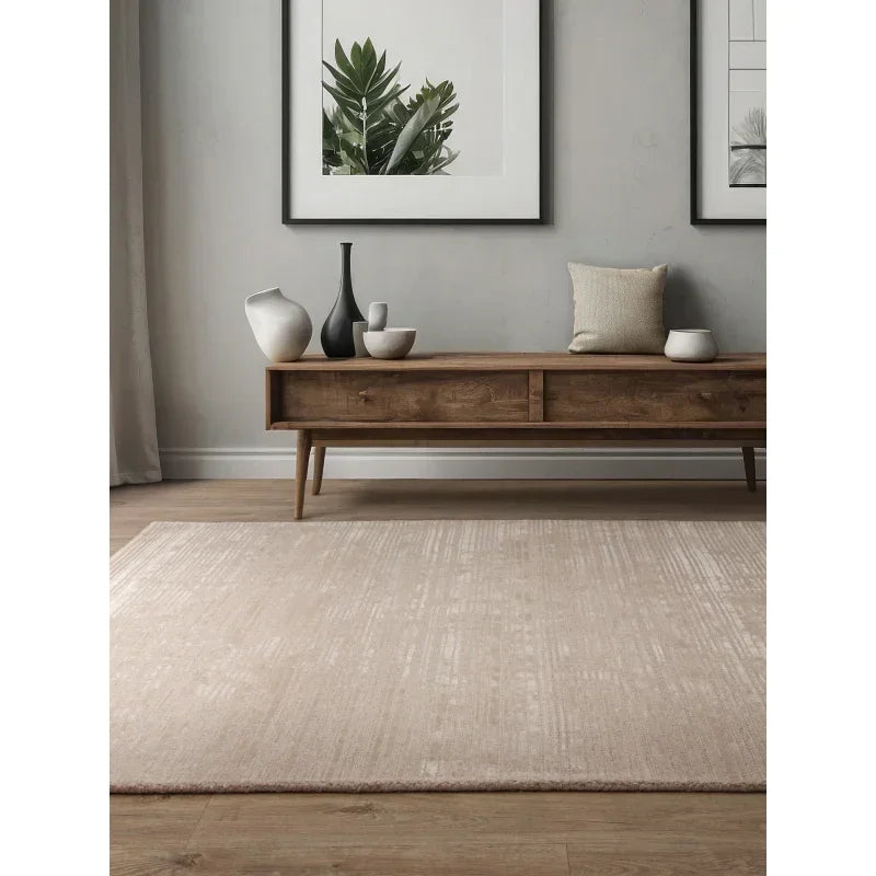 Beige area rug on wooden floor with mid century console table and modern decor