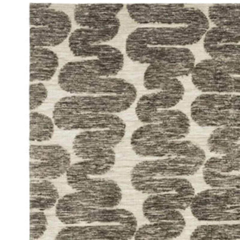 Grey patterned area rug with abstract wave design on a cream background