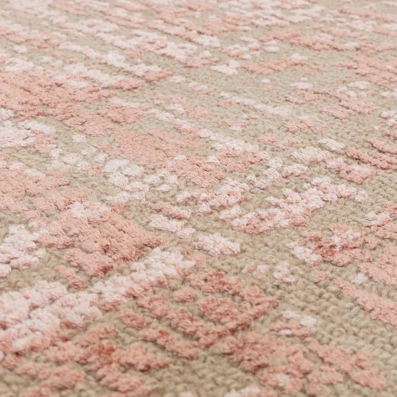 Closeup of textured pink and beige patterned rug surface