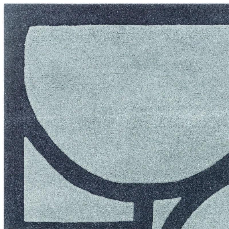 Modern area rug with abstract black geometric lines on a light grey background, corner view
