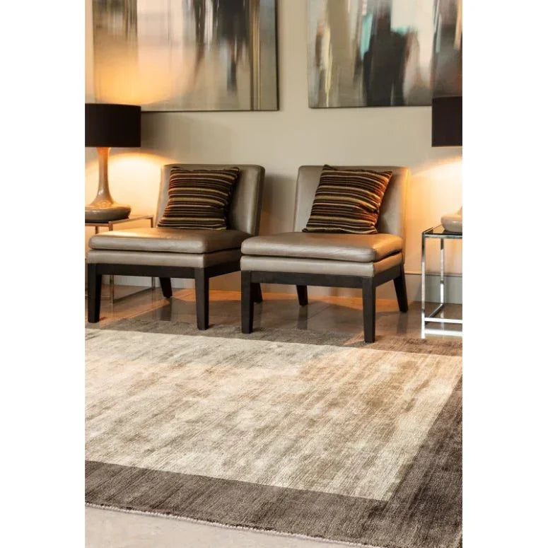 Modern living room with neutral area rug, two brown accent chairs and striped cushions