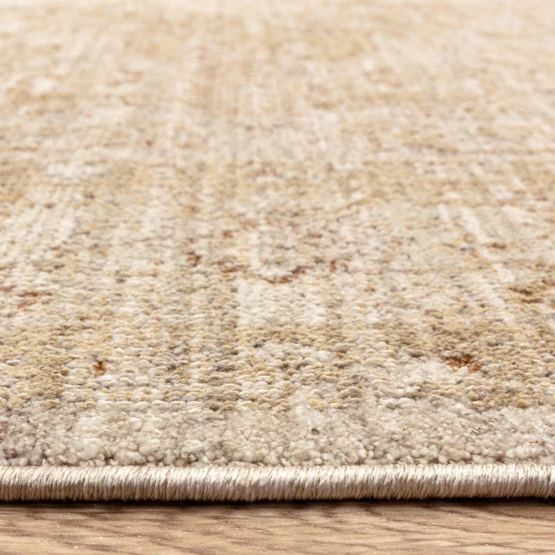 Beige textured area rug with low pile edge on wooden floor
