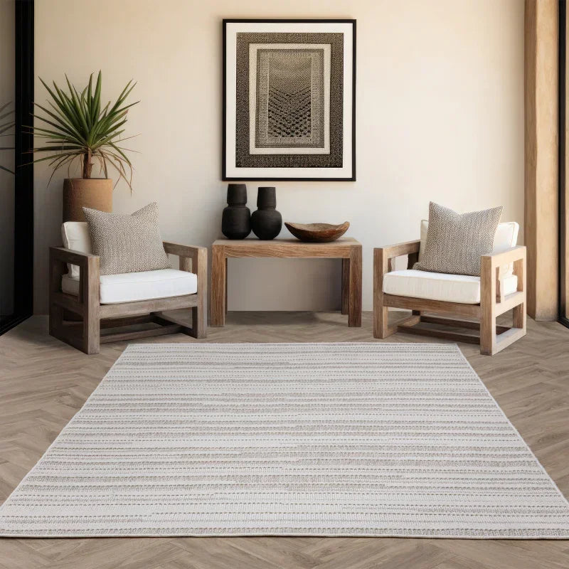 Striped neutral area rug in modern living room with wooden armchairs and side table