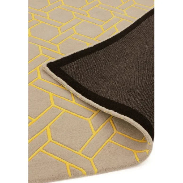Beige area rug with yellow geometric pattern, corner folded to show dark backing