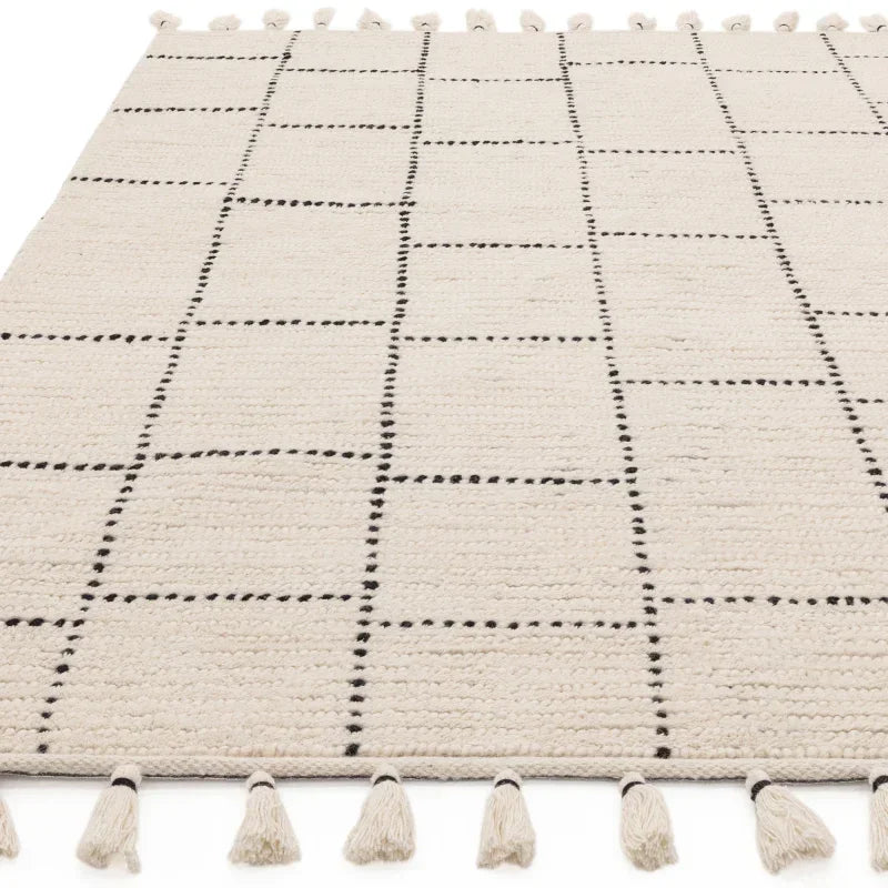 cream woven rug with black grid pattern and tasselled edges