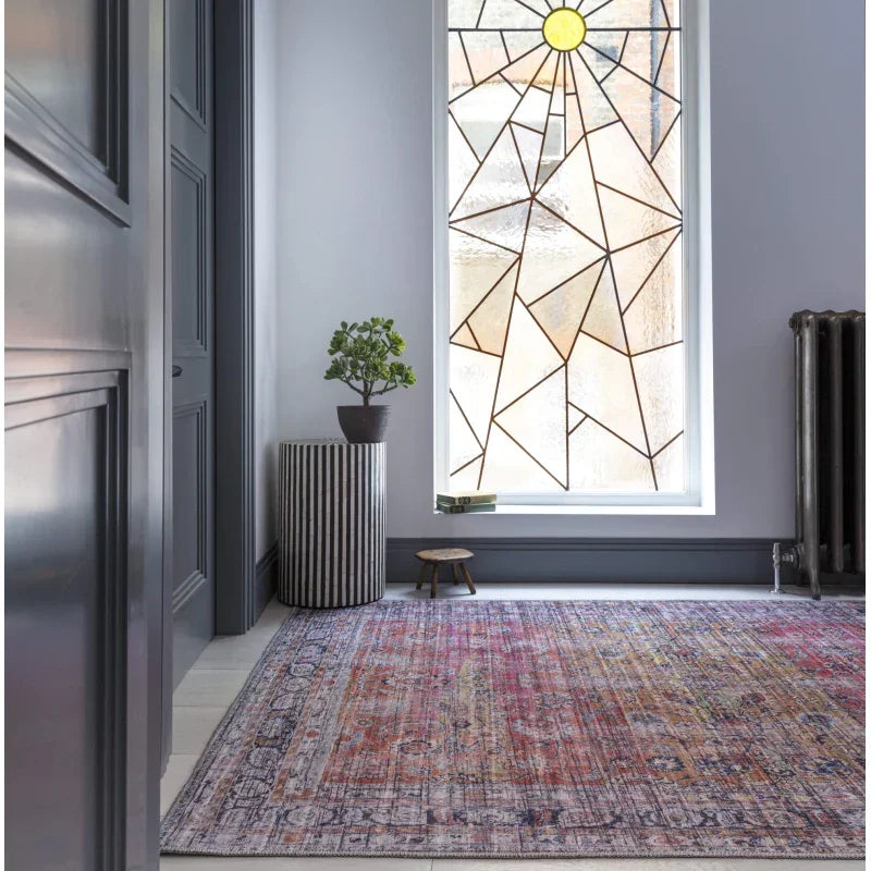 Multicolour distressed area rug in hallway with large geometric stained glass window