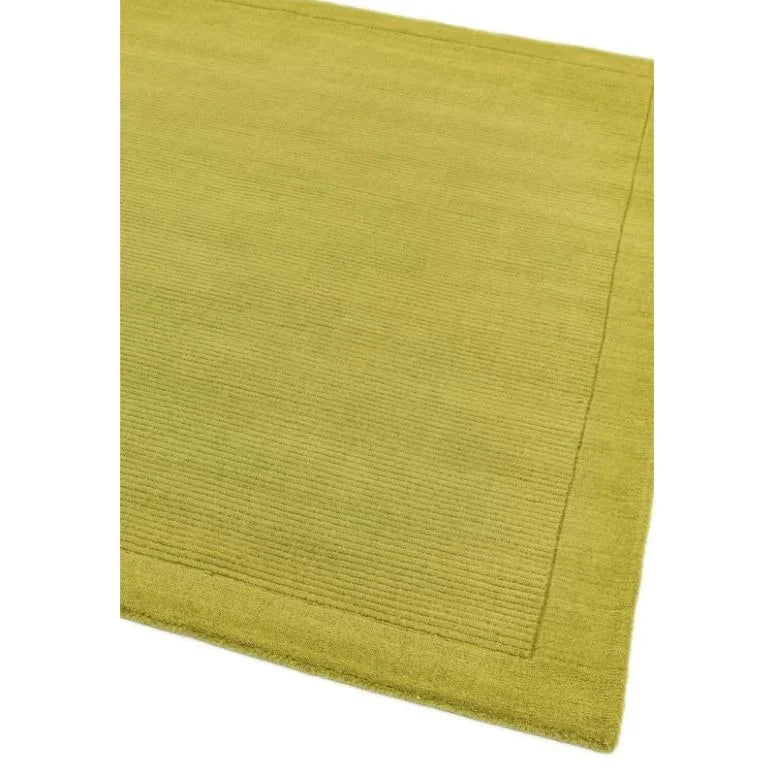 Green area rug with subtle textured border and ribbed pattern close-up