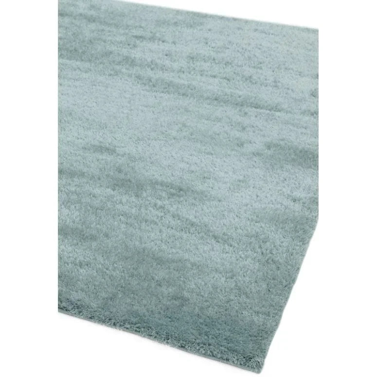 Light blue shaggy rug with soft texture and rectangular shape, close corner view