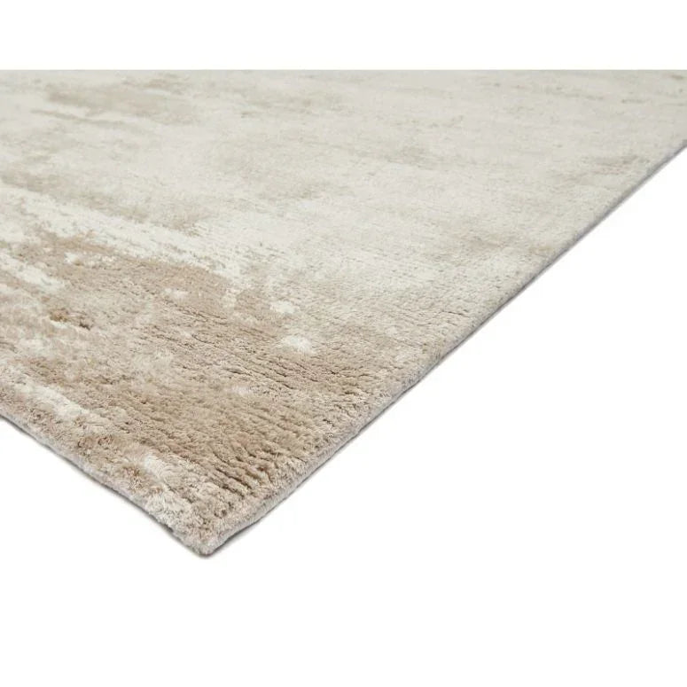 Beige area rug with soft textured pile shown from angled side view