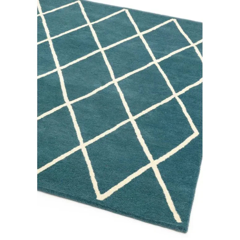 Blue area rug with white geometric diamond pattern, corner view