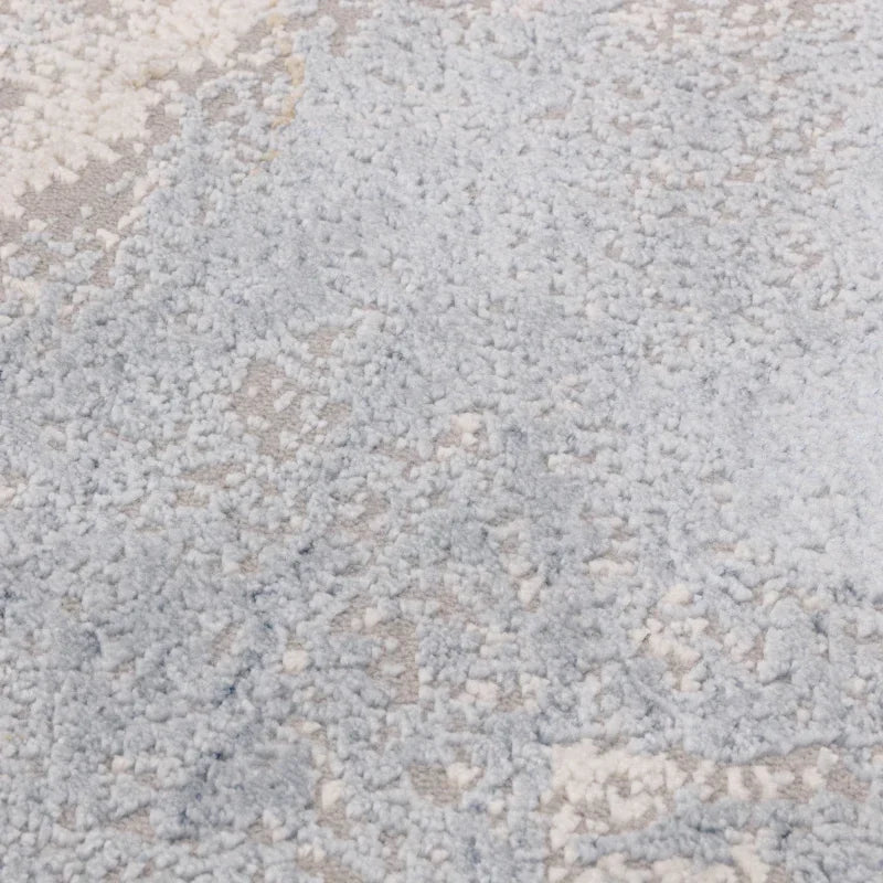 Close-up of blue and cream textured rug fabric with soft pile